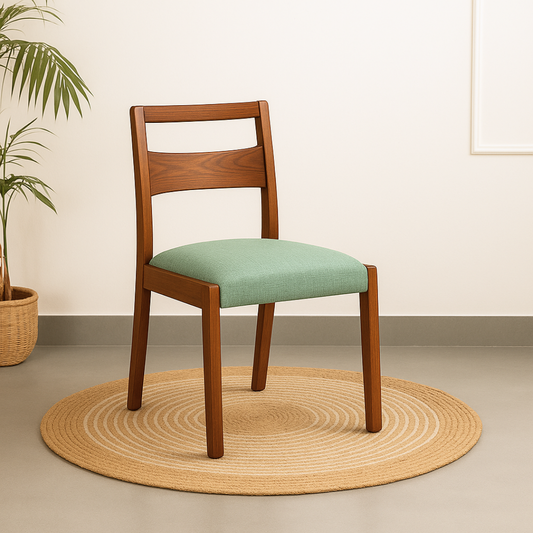 Wooden chair with a green cushion on a beige rug, next to a plant.