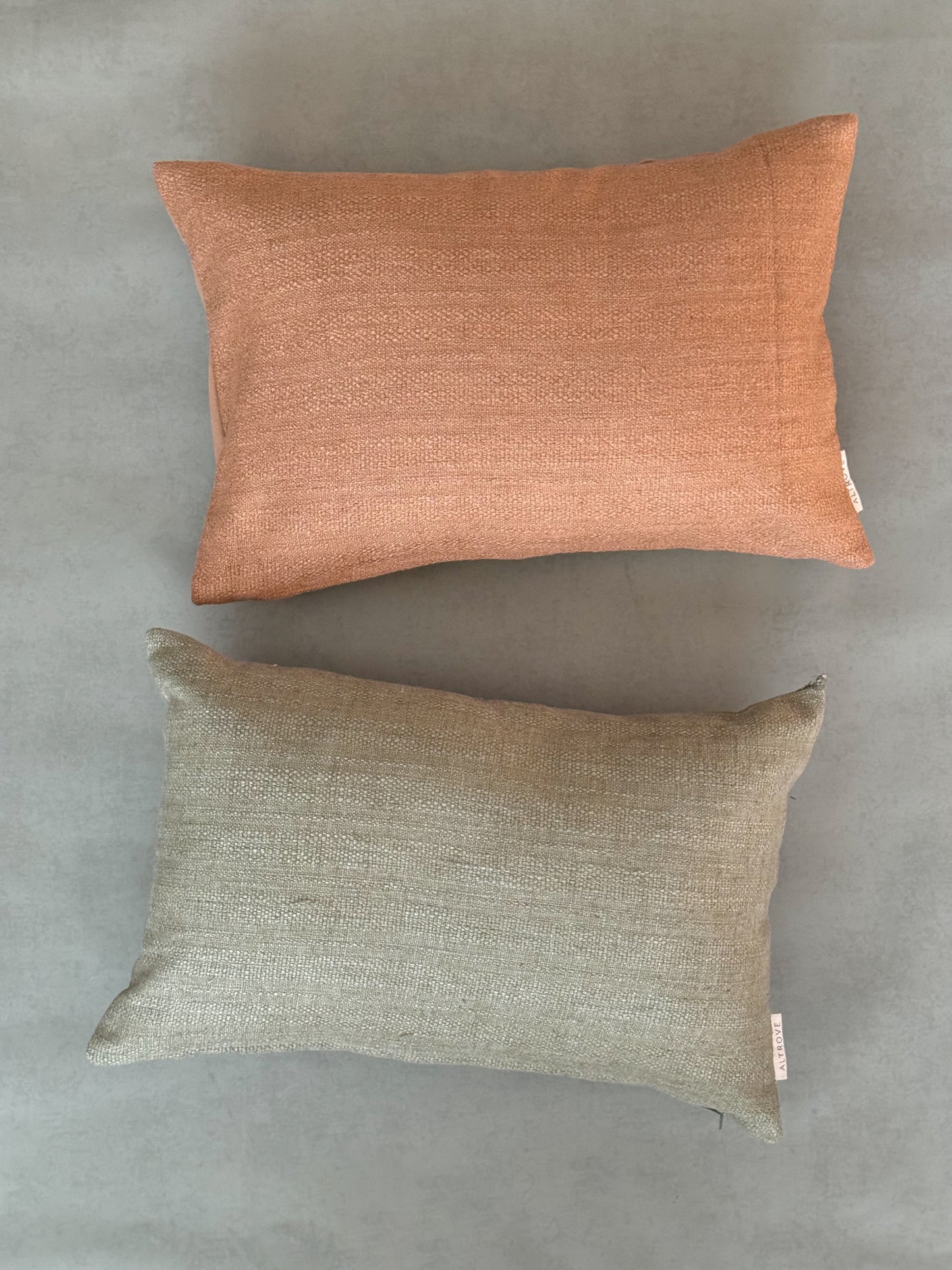 Textured natural green and brown shade cotton oblong cushions.