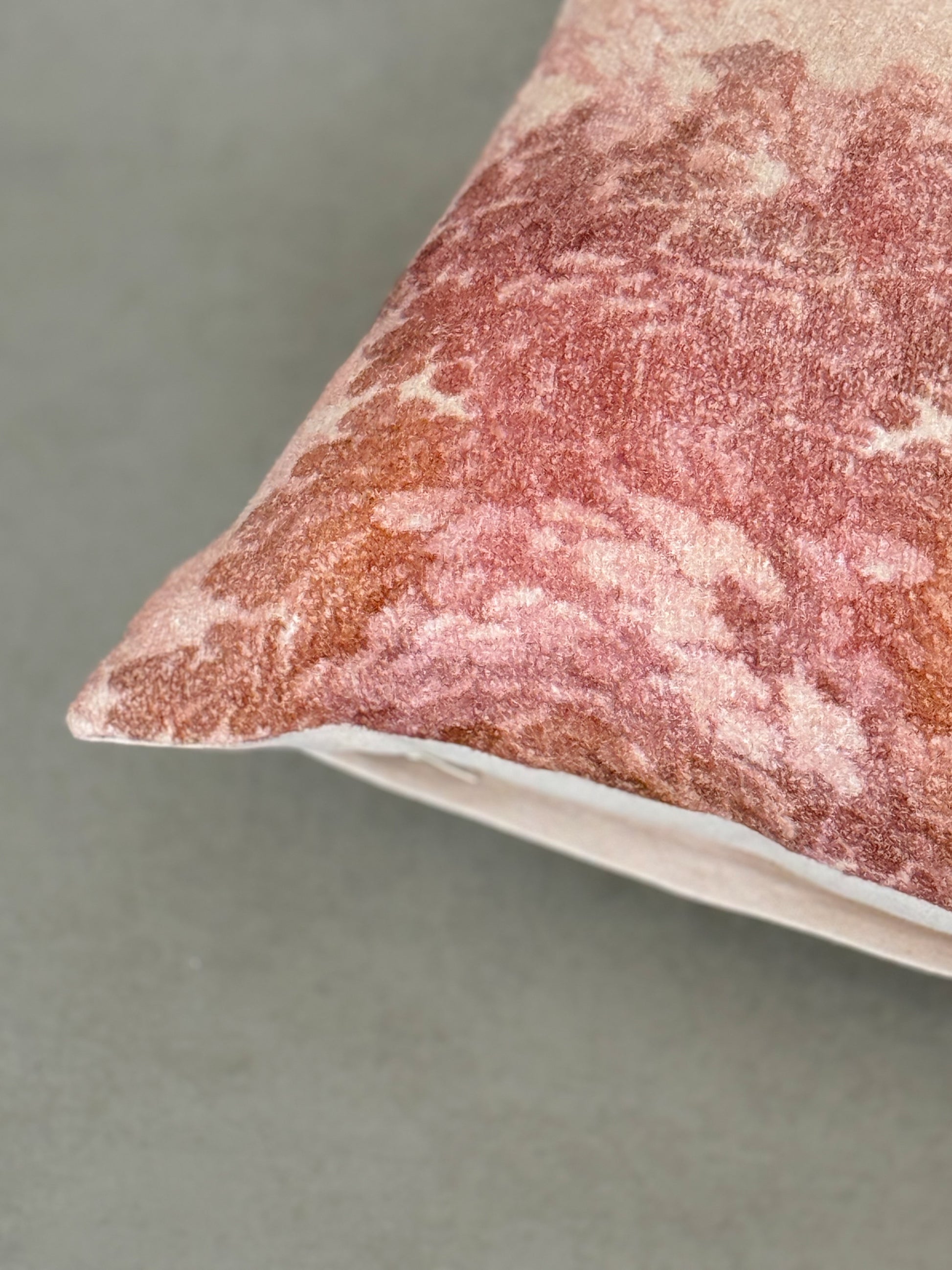 Close up of a digital printed body pillow with leafy branches in subtle brown and blush tones.