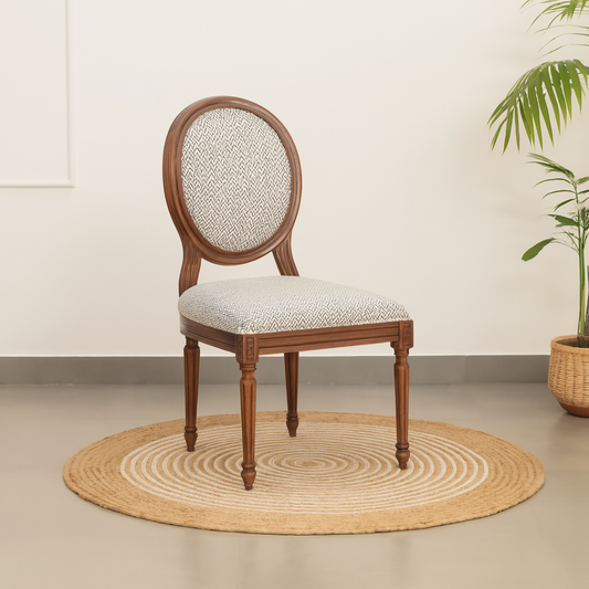 Wooden chair with patterned cushion on a beige rug.