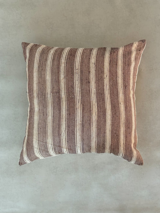 Striped pillow with brown and beige pattern on a plain background