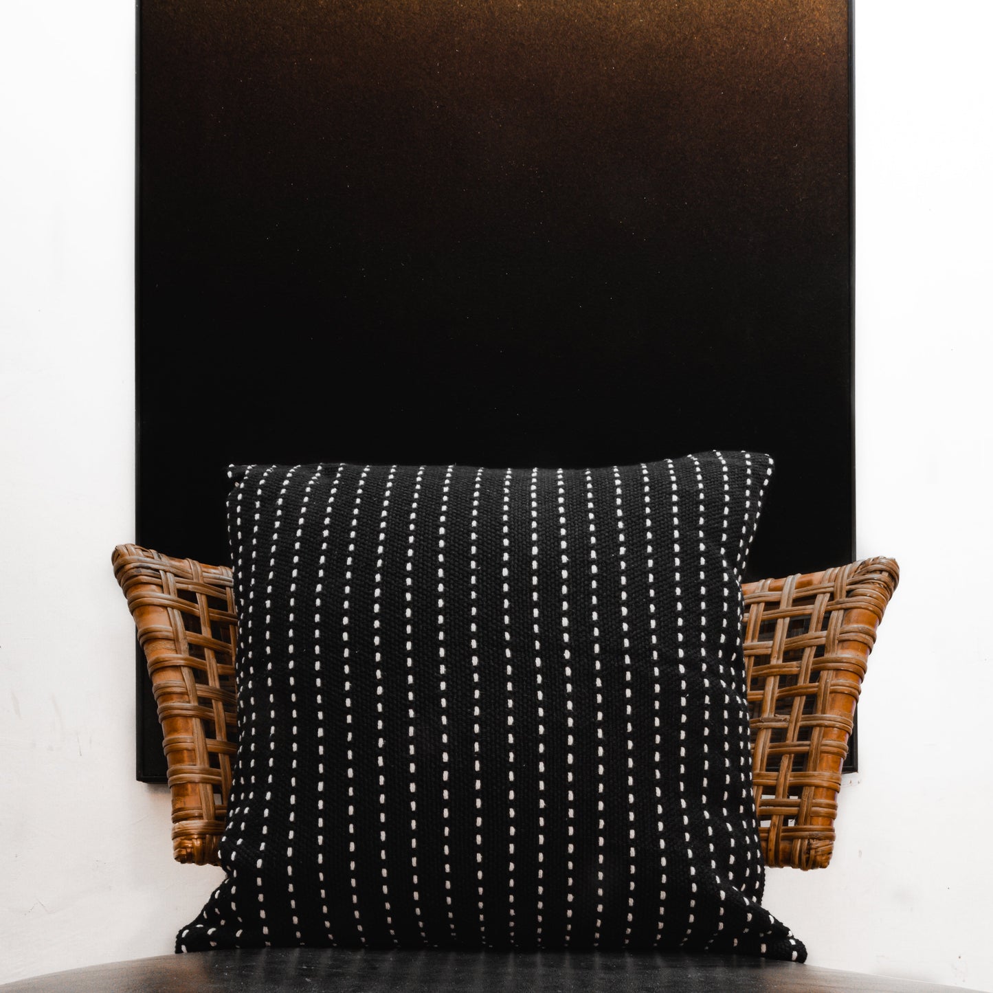 Black Cotton Running Stitch Cushion Cover on a chair